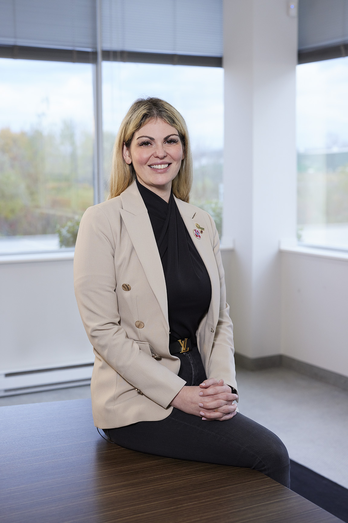 Sabrina Fiorellino, CEO of Fero International Inc. Sitting on desk and smiling