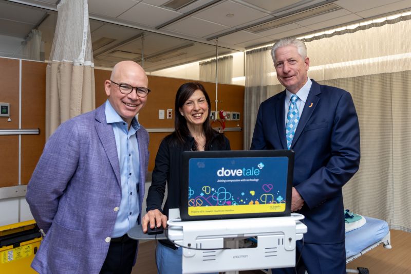 HBR 0625 June 25 Two men and a woman in a hospital, dressed professional, presenting a new technology. Text: Dovetail