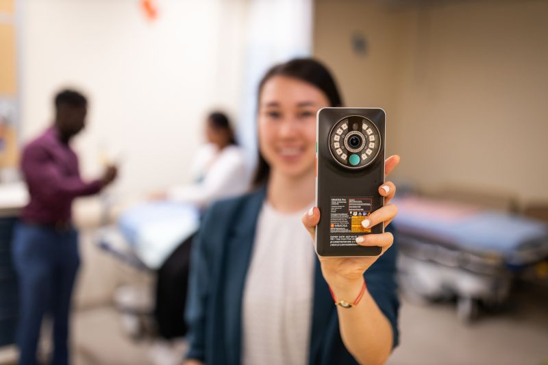 HBR 0925 Sept 18 Woman holding medical device in a clinic.