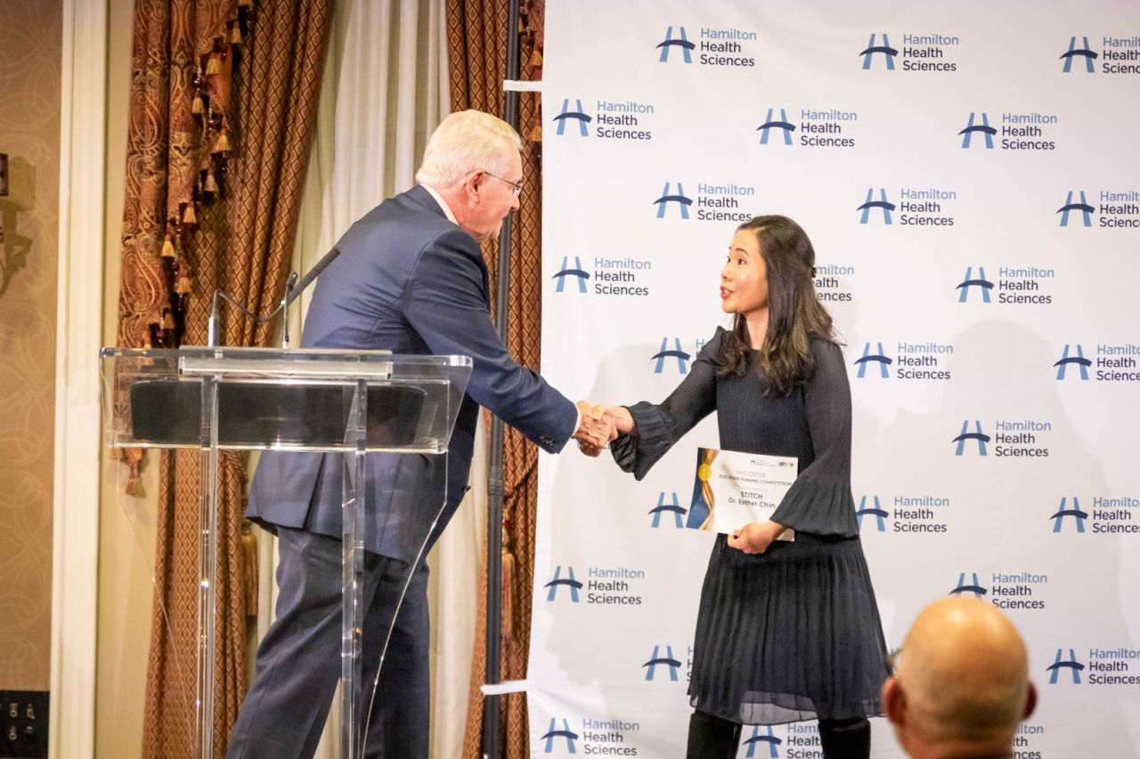 A man presenting a women with an award at a conference.